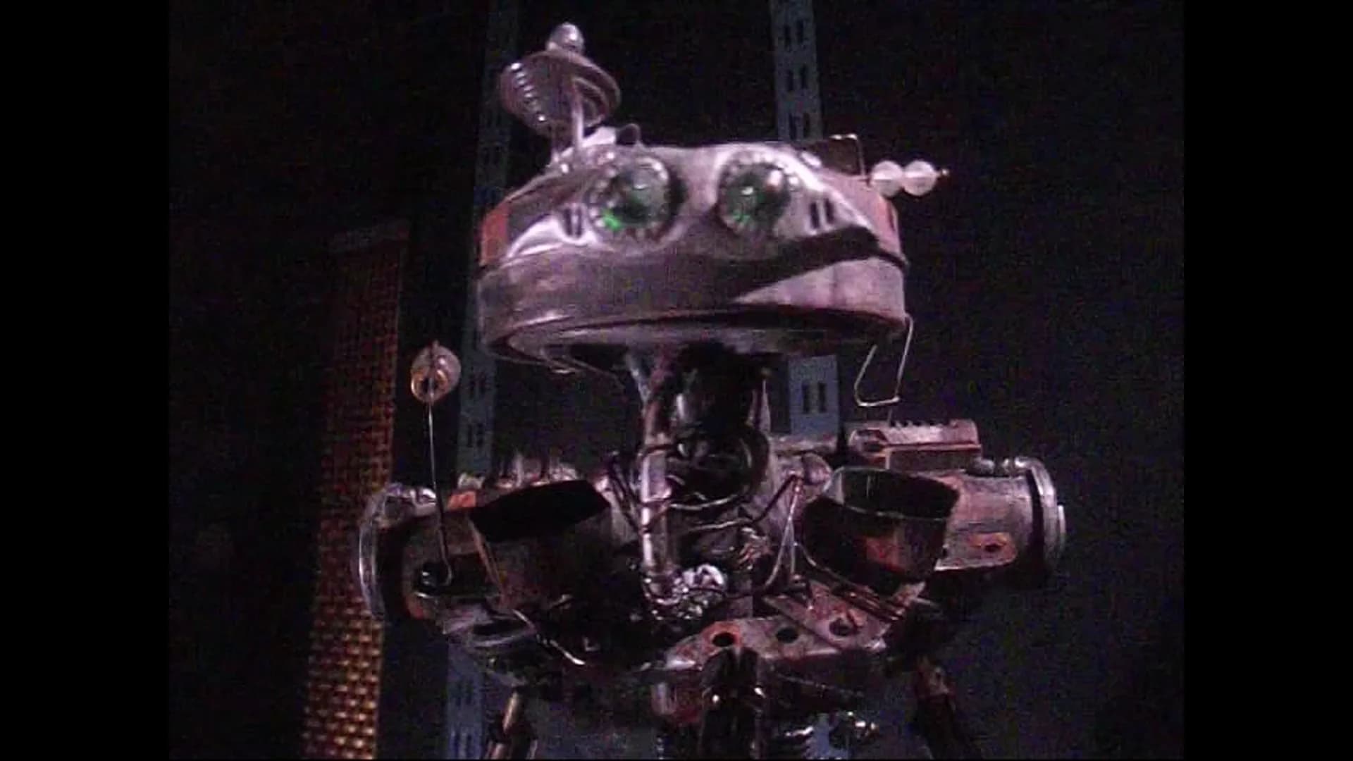 Skim, a mechanical creature with exposed wiring, emerging from the darkness.